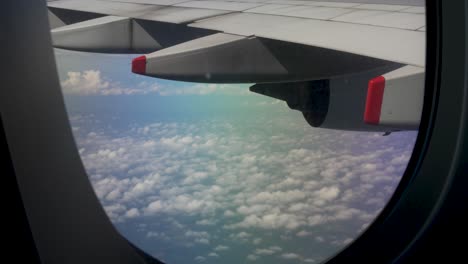 The-passenger-plane-window-in-flight-reveals-an-expansive-panorama-of-the-skies,-where-billowing-clouds-stretch-as-far-as-the-eye-can-see,-traveling-and-air-transportation-concept
