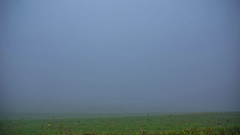 Der-Lufttanz-Der-Wolken,-Die-Elegant-über-Die-Leuchtend-Grünen-Felder-Mit-Einigen-Hütten-Gleiten,-Bietet-Aus-Der-Zeitrafferperspektive-Einen-Bezaubernden-Anblick
