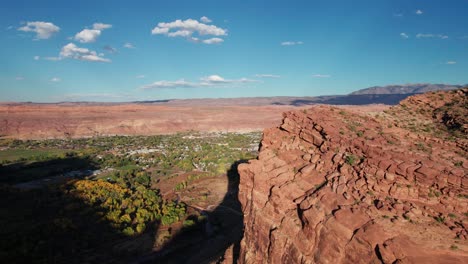 Drone-aerial-shot-revealing-the-entire-city-of-moab,-utah-on-a-sunny-day