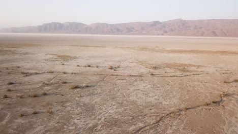 Fliegen-Sie-über-Einen-Salzsee,-Einen-Wüstengebirgshintergrund,-Einen-Drohnenschuss,-Eine-Weite-Aussicht,-Eine-Malerische-Landschaft-Mit-Einem-Wunderbaren-Simmer-Feigengarten,-Erntezeit-Im-Gebirgsvorland,-Traditionelle-Landwirtschaft,-Ländliche-Landschaft-Im-Iran