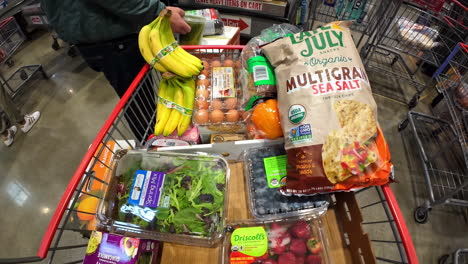 Time-lapse-of-a-shopping-cart-full-of-grocery-and-goods,-checking-out-at-the-cashier