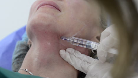 Hands-of-female-doctor-injecting-botox-with-syringe-on-woman´s-chin