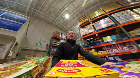 A-young-man-pushes-a-shopping-cart-through-a-huge-supermarket
