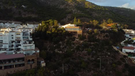 Luxury-private-villa-lit-with-sunset-light-in-Mijas-town,-aerial-view
