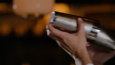 Closeup-shot-of-a-bartender-shaking-a-cocktail-in-a-cocktail-shaker