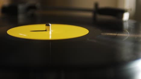 Close-Up-of-a-Yellow-Spinning-Vinyl-on-a-Record-Player
