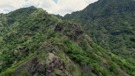 Drone-Volando-Sobre-La-Cima-De-Una-Montaña-Rocosa-Con-Vegetación-Verde