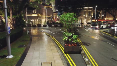 Filmaufnahme,-Während-Die-Drohne-Mit-Bus-Und-Telsa-Gleitet-Und-Sich-In-Richtung-Marina-Bay-Sands-Singapur-Dreht