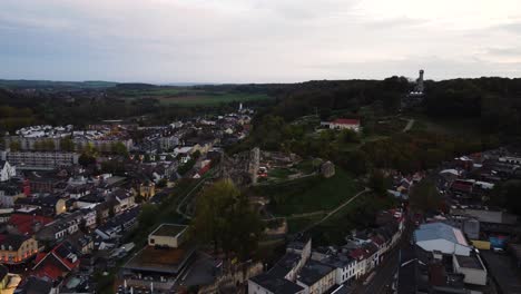 Castle-ruins-of-Valkenburg-after-sunset,-aerial-drone-view