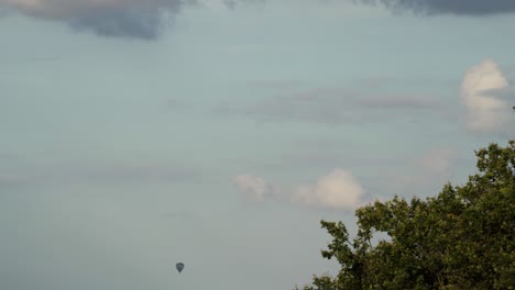 Hot-air-balloon-floating-in-the-sky,-distance-time-lapse-view