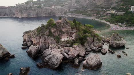 Drohne-Kreist-Bei-Sonnenuntergang-Um-Die-Insel-Isola-Bella-In-Der-Nähe-Der-Küste-Von-Taormina