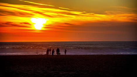Time-lapse-of-people-on-Manhattan-beach,-colorful-sunset-in-California,-USA