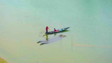 Zwei-Fischer-Rudern-In-Einem-Schmalen-Boot-In-Einem-Ruhigen-Fluss-In-Bangladesch