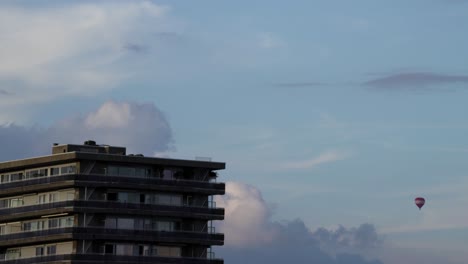 Apartment-building-of-Antwerp-with-hot-air-balloon-in-distance,-time-lapse