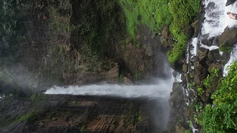 Tourists-get-wet-below-powerful-Karas-Biru-waterfall-on-Java,-IDN