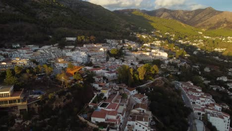 Sun-glowing-on-Mijas-township-in-Spain-mountains,-aerial-drone-view