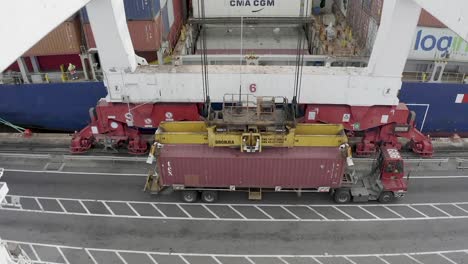 Heavy-loader-crane-moves-container-onto-tanker-boat-at-port-preparing-for-transit