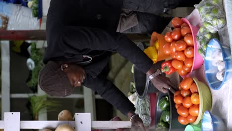 A-Vendor-Showcasing-Their-Goods-at-a-Market-in-Africa---Vertical-Shot