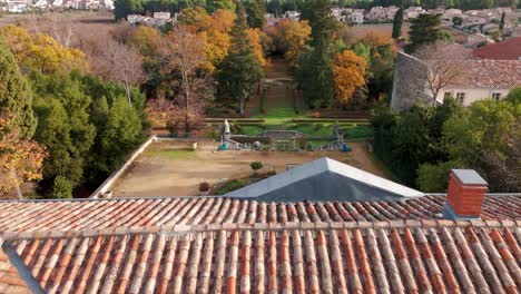 Aerial-over-big-french-mansion-with-scenic-view-of-the-garden-in-small-village-jacou