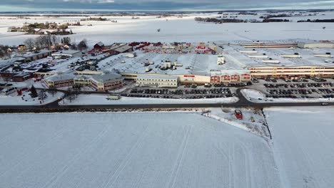 Aerial-approach---Väderstad-AB-agricultural-machine-factory-buildings---Snow,-winter-and-sunny-weather
