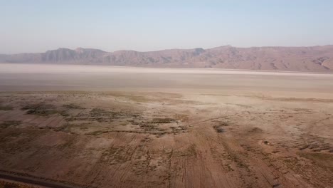 Drohnenaufnahme-Eines-Wunderschönen-Salzsees-In-Der-Wüstenlandschaft-Des-Nahen-Ostens,-Asien,-Weiter-Panoramablick-Auf-Die-Skyline-An-Dunstigen-Tagen,-Fars-Landschaft-In-Ländlichen-Dorfbergen-In-Der-Sommersaison-Im-Iran,-Weißes-Salzmineral