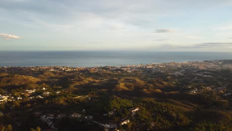 Panorama-of-coastal-town-of-Spain-during-sunset,-aerial-drone-view