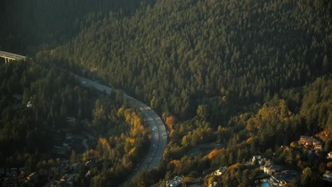 Highway-Bridge-in-a-Mountainous-Forest-Landscape---Golden-Hour-Aerial