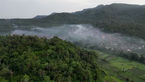Drone-flying-over-a-village-with-smoke-from-burning-garbage-covering-the-village