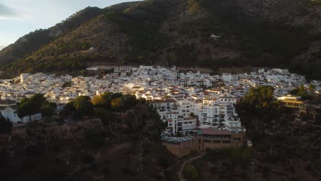 Sunset-sun-glowing-on-white-township-of-Mijas,-aerial-view