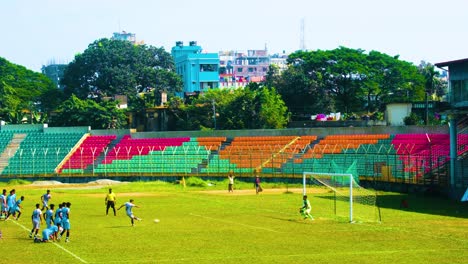 High-angle-shot-of-a-friendly-junior-match-between-local-football-teams-in-Bangladesh-on-a-sunny-day