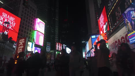Driving-past-colorful-banners-and-ads-at-the-Times-square,-night-in-New-York