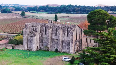Historic-architectural-gem,-Abbey-of-Vignogoul,-captured-in-aerial-arc-shot