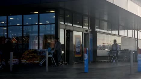 Customers-entering-ALDI-brand-supermarket-buying-cheap-food-time-lapse