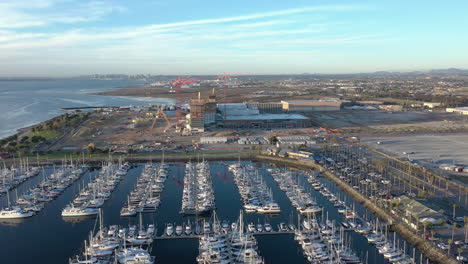 The-new-convention-center-being-build-in-Chula-Vista-California,-with-San-Diego-skyline-in-the-distance,-marina-with-boats-in-the-foreground