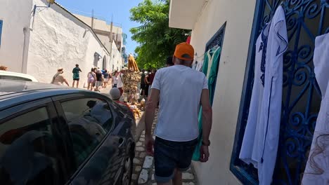 Follow-me-shot-in-the-main-street-with-tourists-in-Sidi-Bou-Said,-Tunisia