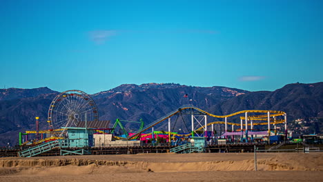 Santa-Monica-Pier-and-amusement-rides-on-the-beach-with-mountains-in-the-background---time-lapse