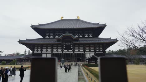 Vast-Todai-ji-Temple-in-Nara-with-tourists-exploring-its-grandeur,-overcast-weather