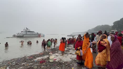 Wide-shot-of-Hindus-bathing-in-Babu-ghat,-Kolkata-for-the-celebration-of-Sankranti-festival-during-cloudy-evening-in-India