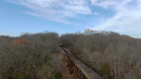 Aerial-Shot-of-Three-Norfolk-Southern-Engines-Leading-an-Intermodal-Train-on-to-the-Pope-Lick-Trestle-in-Louisville,-Kentucky-during-the-Winter