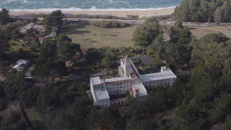 4K-cinematic-drone-shot-of-the-Carmelite-Monastery-with-the-Pacific-Coast-Highway-and-Monastery-Beach-in-the-background