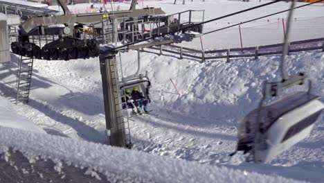 Two-people-on-a-chairlift-in-a-ski-resort-in-Italy