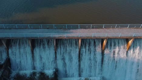 Aerial-shot-of-water-flowing-through-the-floodgate-of-a-dam-of-a-lake-made-for-irrigation