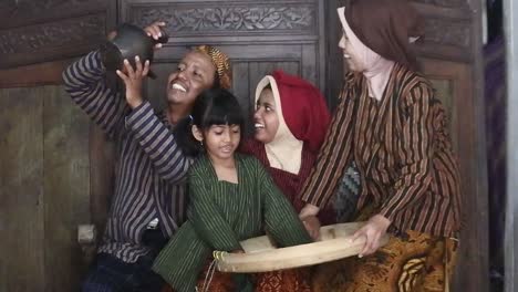 Ein-Glückliches-Javanisches-Familienpaar-Mit-Seinen-Beiden-Kindern-Mit-Einem-Irdenen-Krug,-Zentral-Java,-Indonesien