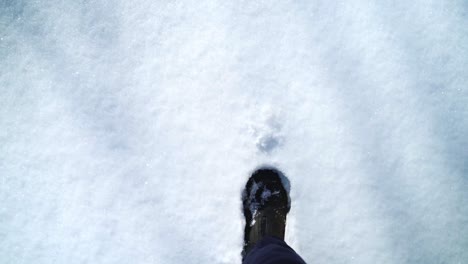 Close-up-walking-foot-point-of-view-on-snow-carpet-in-winter