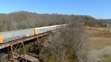 Aerial-Shot-of-an-Auto-Carrier-Train-Heading-on-to-the-Pope-Lick-Trestle-in-Louisville,-Kentucky-on-a-Sunny-Winter-Day