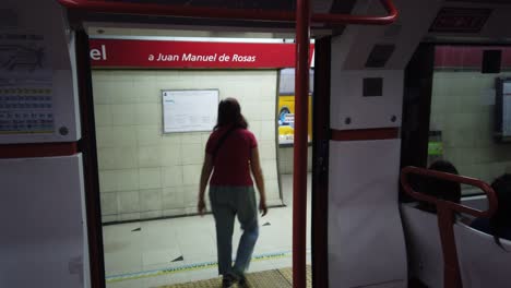 Red-Subway-Stops-at-Underground-Metro-Station,-a-Senior-Lady-Walks-Down,-Doors-Open