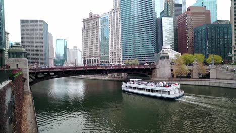 River-cruise-boat-sailing-at-Chicago-downtown-city-daylight-in-winter-slow-motion-long-shot