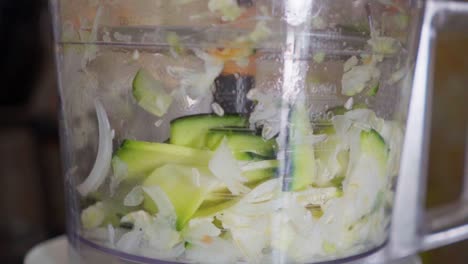 Zeitlupen-Nahaufnahme-Einer-Küchenmaschine,-Die-Zucchini-Zerkleinert