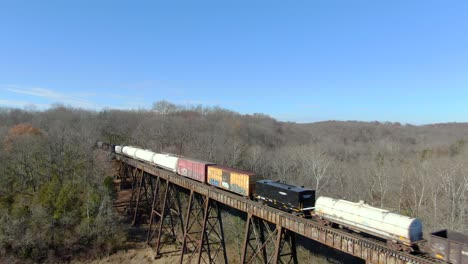 Aerial-Shot-Pulling-Back-from-a-Mixed-Freight-Train-Crossing-the-Pope-Lick-Trestle-in-Louisville,-Kentucky-on-a-Sunny-Winter-Day