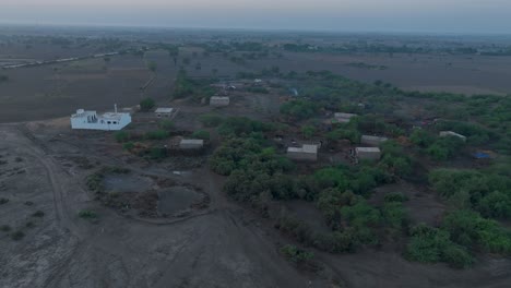 Vista-De-Drones-De-Casas-Dispersas-En-La-Aldea-Rural-De-Sindh-Durante-La-Puesta-De-Sol-En-Pakistán